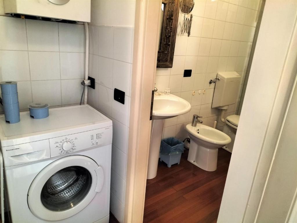 a small bathroom with a washing machine and a sink at Donizetti Elegant Apartment in Florence