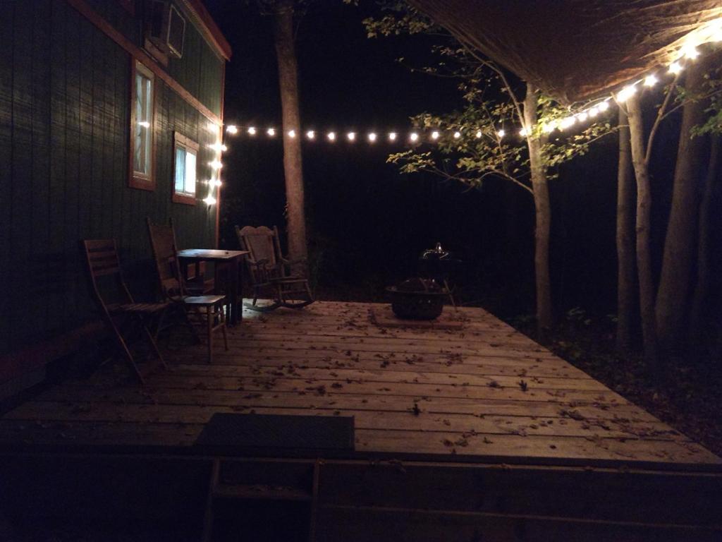 - un patio la nuit avec une table et des lumières dans l'établissement Rural Tiny House in the Edge Of the Woods, à Chesapeake