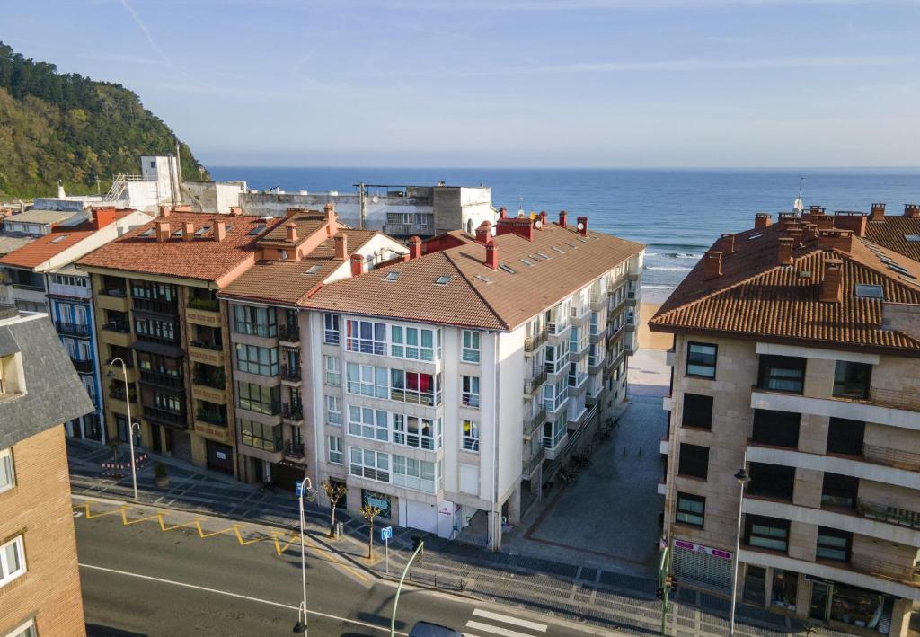 a group of buildings with the ocean in the background at Egona- Vivienda en el centro de Zarautz a 1 min de la playa in Zarautz
