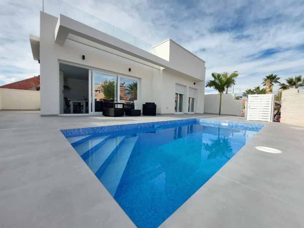 a swimming pool in front of a villa at Villa María in Alicante