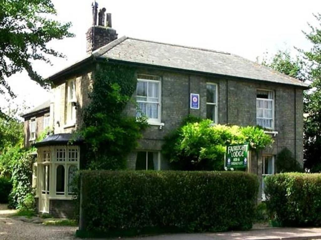 a large brick house with a sign in front of it at Fairlight Lodge in Kings Lynn