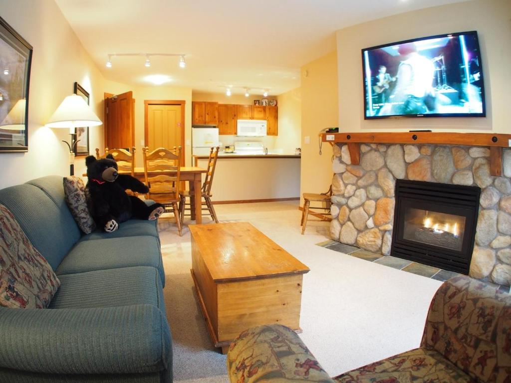 sala de estar con sofá y chimenea en Fireside Lodge #302 By Bear Country, en Sun Peaks