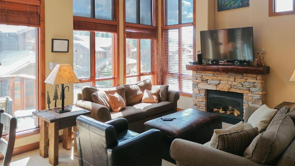 uma sala de estar com um sofá e uma lareira em Woodhaven #19 by Bear Country em Sun Peaks