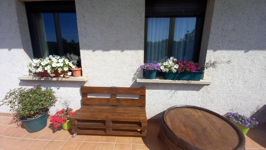 a wooden bench sitting in front of two windows at casa apartamento en Riezu Mapi etxea in Riezu