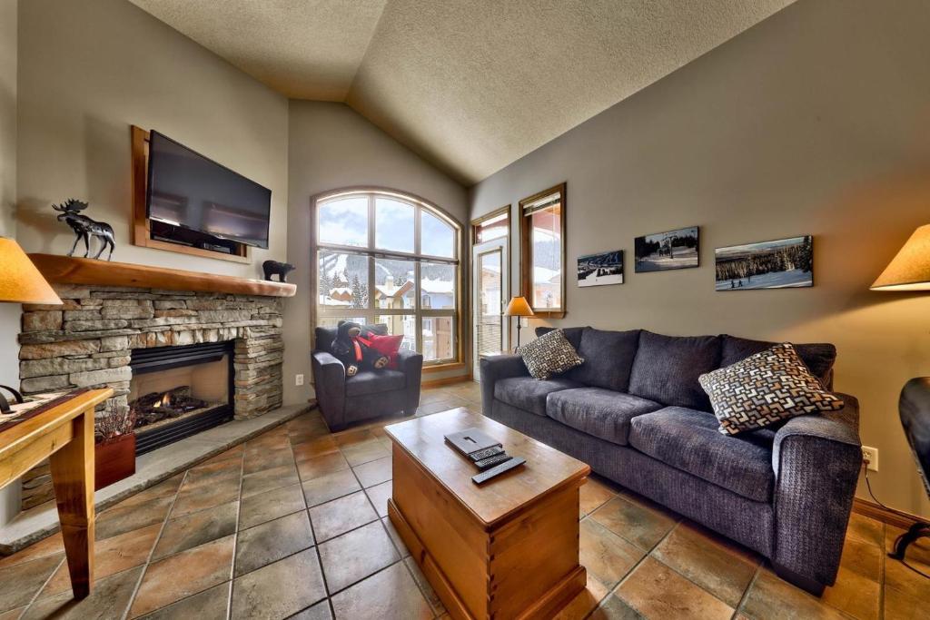 a living room with a couch and a fireplace at Crystal Forest #72 By Bear Country in Sun Peaks
