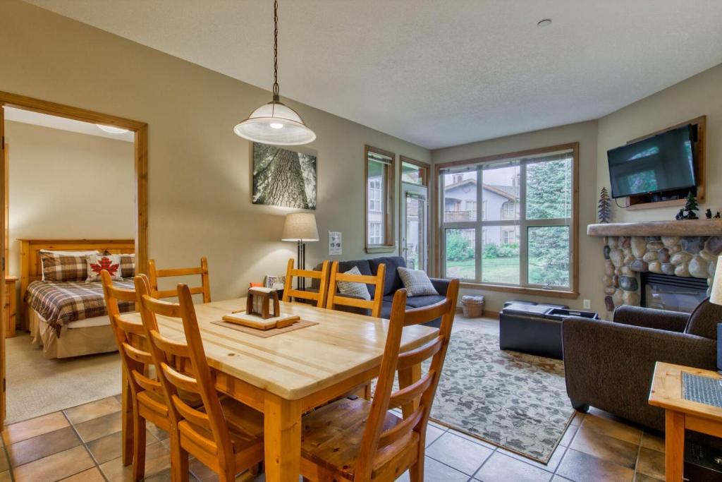 a dining room and living room with a table and chairs at Crystal Forest #65 By Bear Country in Sun Peaks
