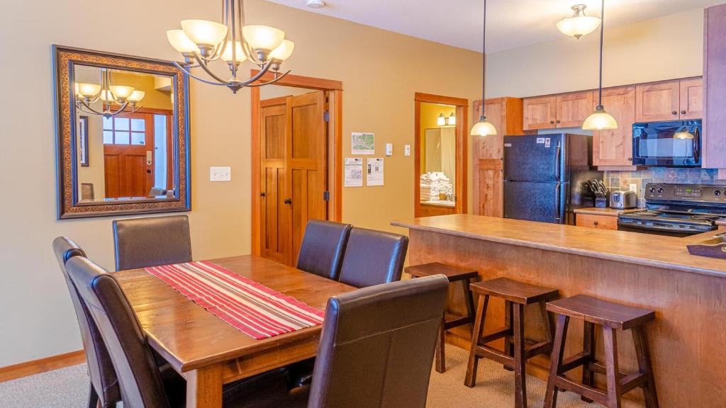 cocina y comedor con mesa de madera y sillas en Settlers Crossing #61 by Bear Country en Sun Peaks