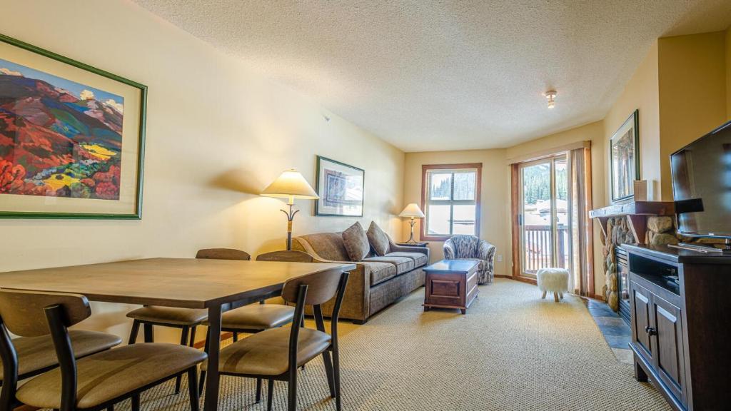 a living room with a table and a couch at Fireside Lodge #413 By Bear Country in Sun Peaks