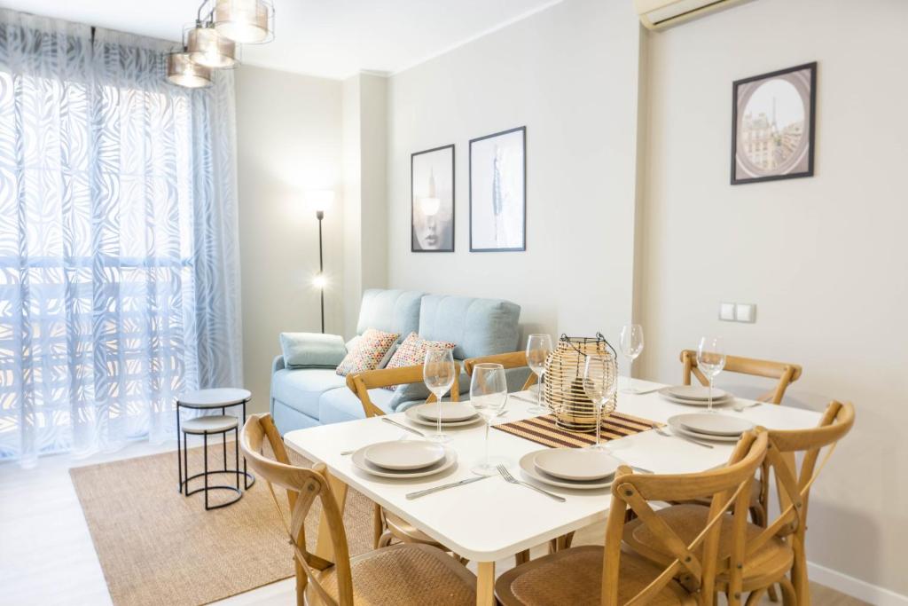 ein Wohnzimmer mit einem Tisch, Stühlen und einem Sofa in der Unterkunft Luxury Apartment Dos Aceras in Málaga