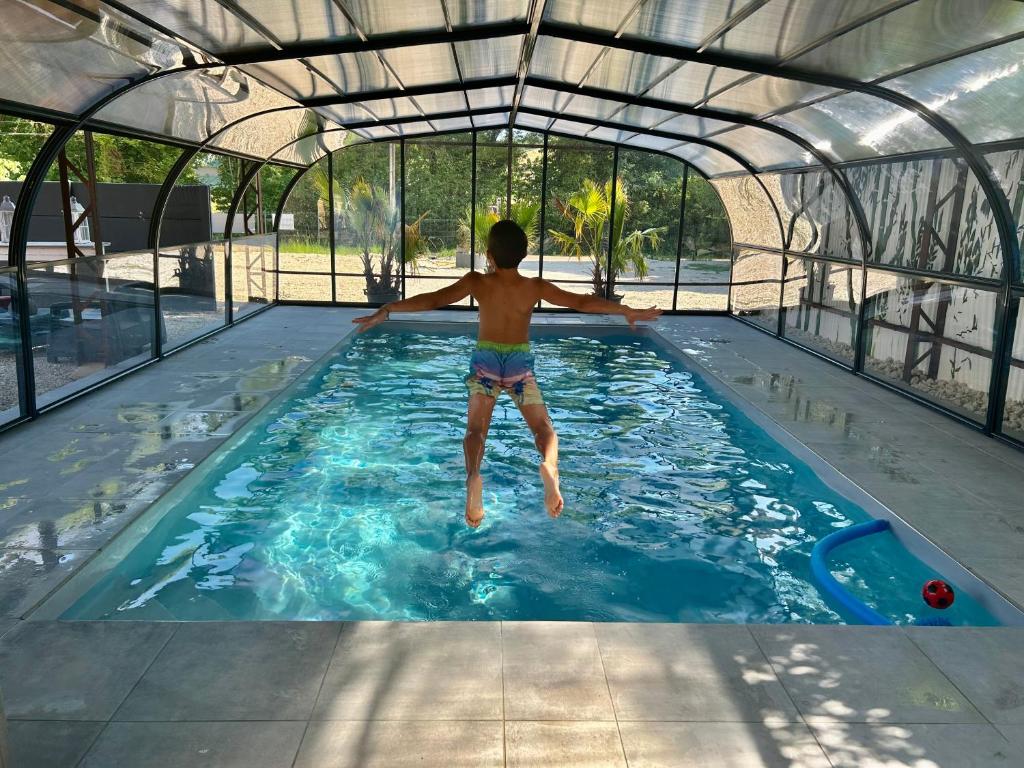un hombre saltando a una piscina en Le Domaine du Lavoir en Villemoiron-en-Othe