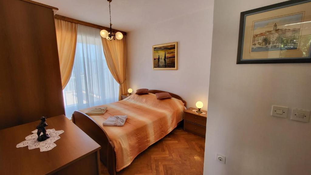 a bedroom with a bed and a desk and a window at VILLA Apartments Mate Cebalo in Lumbarda