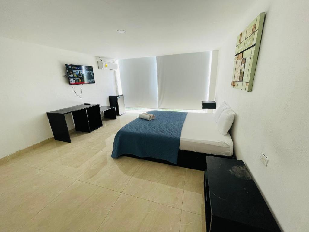 una camera con un letto e due tavoli in una stanza di Gorgona Beach House a Nueva Gorgona