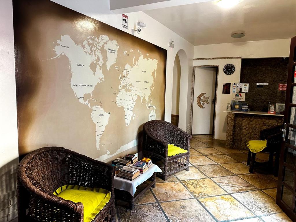 a room with two chairs and a map on the wall at Pousada Alternativa in Canoa Quebrada