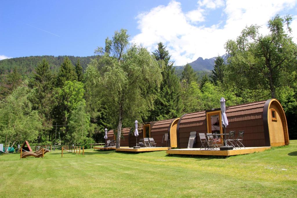 a small building with a playground in a field at Presanella Mountain Lodge in Temù