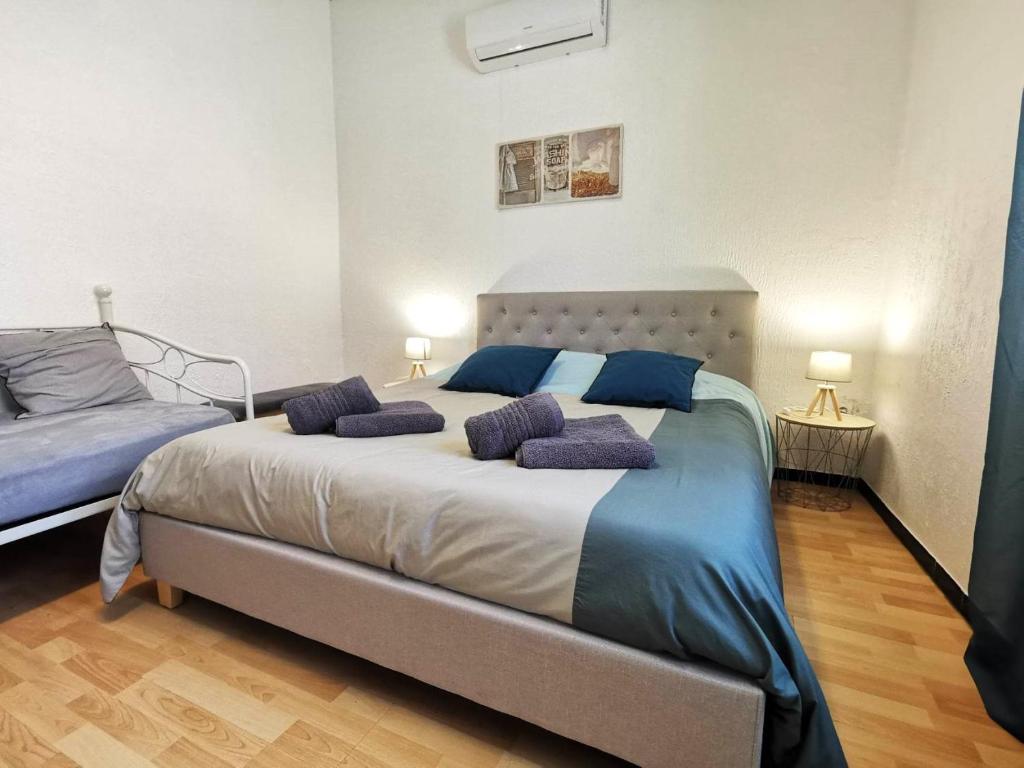 a bedroom with a large bed with purple pillows on it at L'hypercentre - Clim - Terrasse - WIFI in Miramas