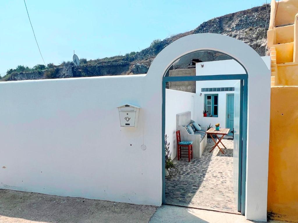 フィラにあるPoli Cave House Santoriniの白い建物のアーチ入口