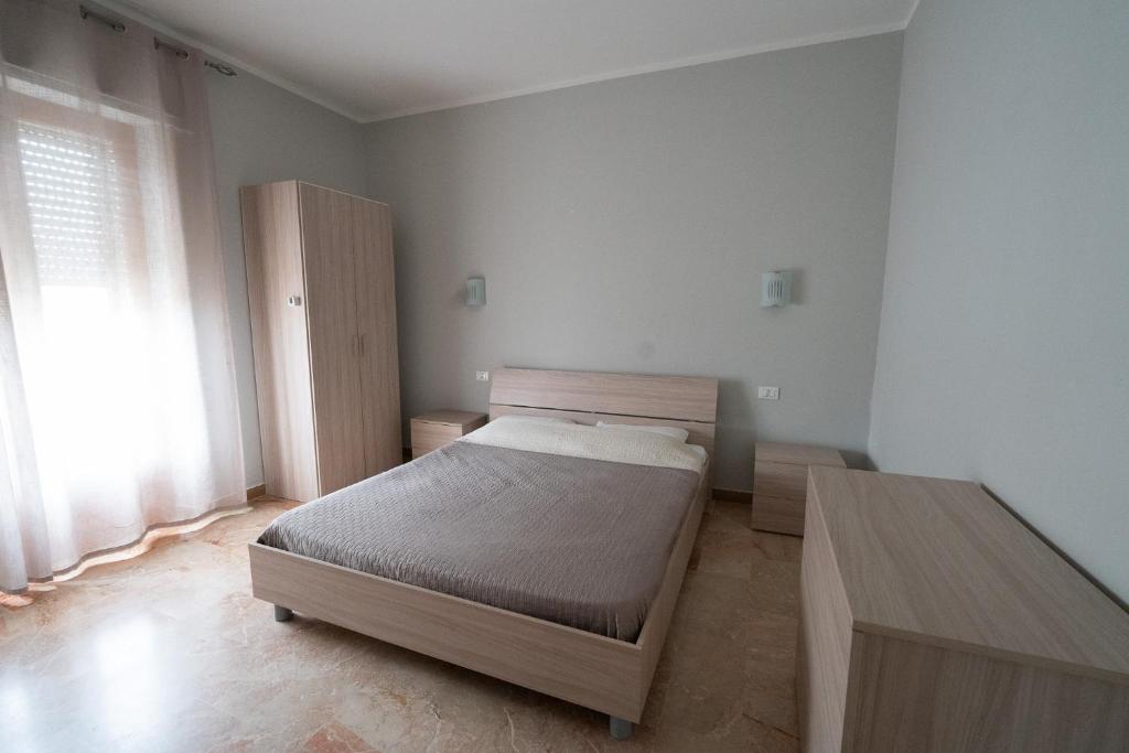 een slaapkamer met een bed en een houten kast bij Sunrise Apartment in Guardavalle