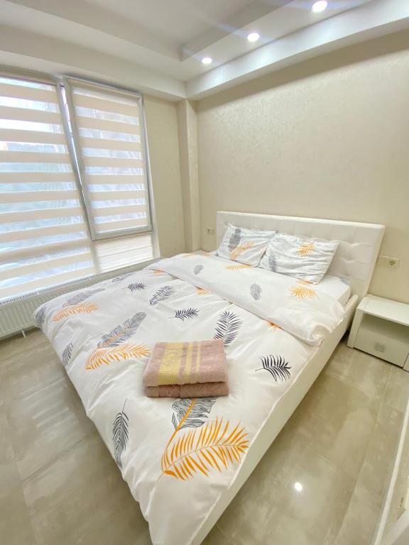 a bedroom with a large white bed with a window at Soimari street New Apartment in Chisinau in Chişinău
