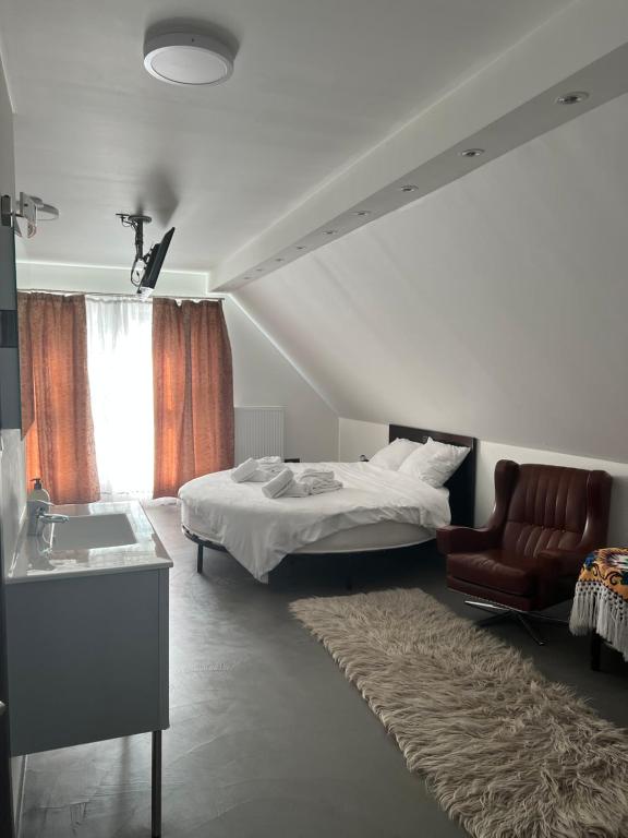 - une chambre avec un lit, une chaise et un lavabo dans l'établissement Les gites du Valjoly, à Touvent