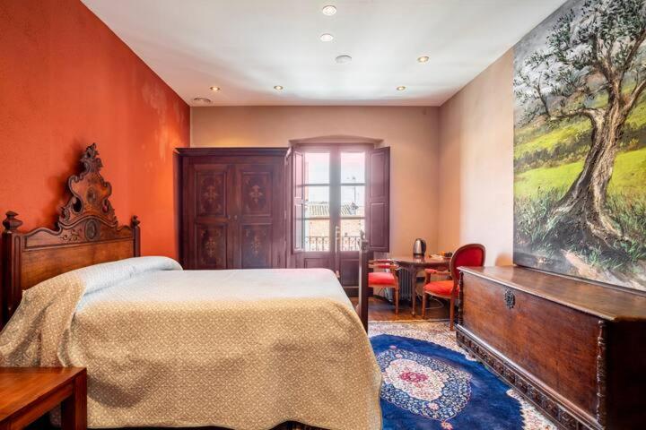 a bedroom with a bed and a large painting on the wall at ca n'Arago, edificio modernista del arquitecto Rafael Maso in Santa Coloma de Farners