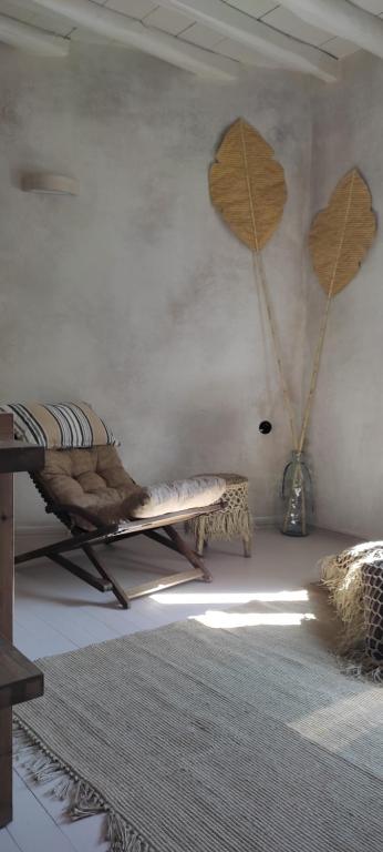 a room with a table and two wooden leaves on the wall at ClockWise Earthy Vibe House in Apano Chora in Ano Syros