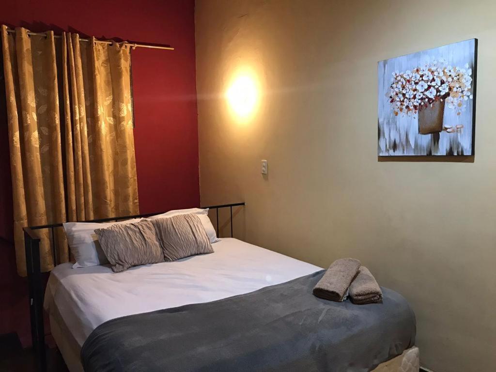 a bedroom with two beds and a painting on the wall at Renty Herrera in Asunción