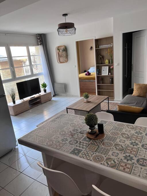 un salon avec une table et une télévision dans l'établissement La petite lumière Dieppoise, à Dieppe