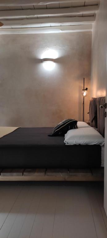 a large bed in a room with a light at ClockWise Earthy Vibe House in Apano Chora in Ano Syros