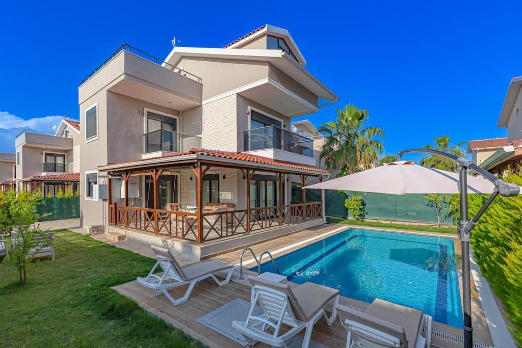 a villa with a swimming pool and a house at Near By THE LAND OF LEGENDS , VİLLA PARADİSE in Belek