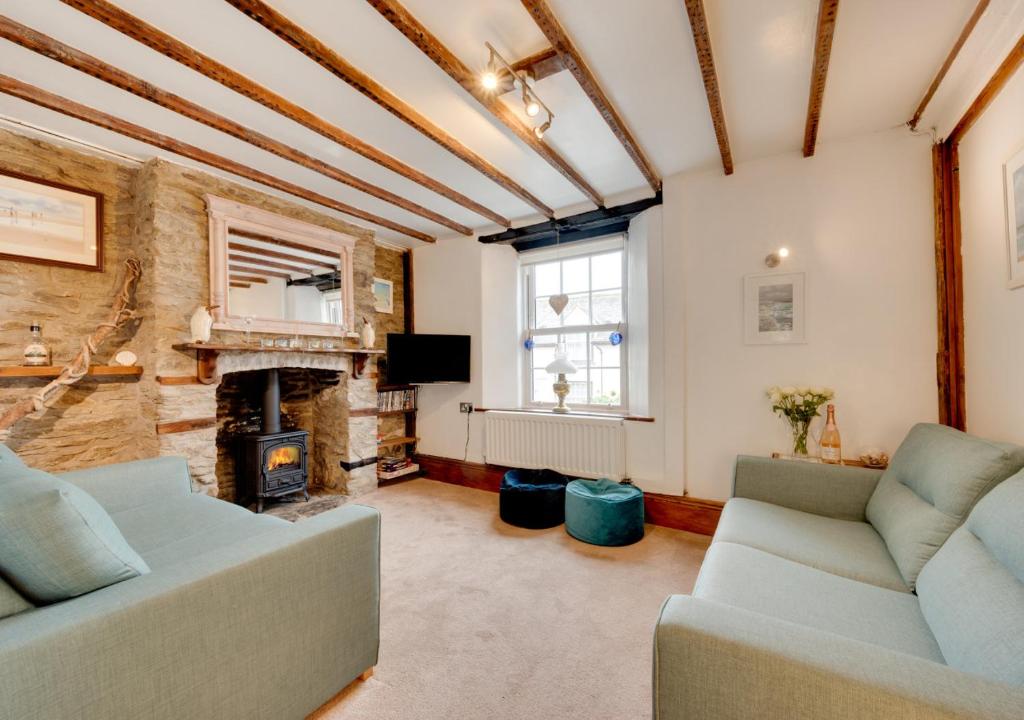 a living room with two couches and a fireplace at Temperance Cottage in Braunton
