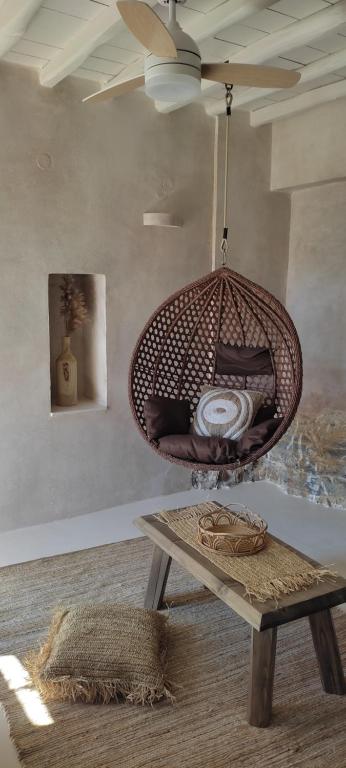 a room with a rattan swing hanging from a ceiling at ClockWise Earthy Vibe House in Apano Chora in Ano Syros