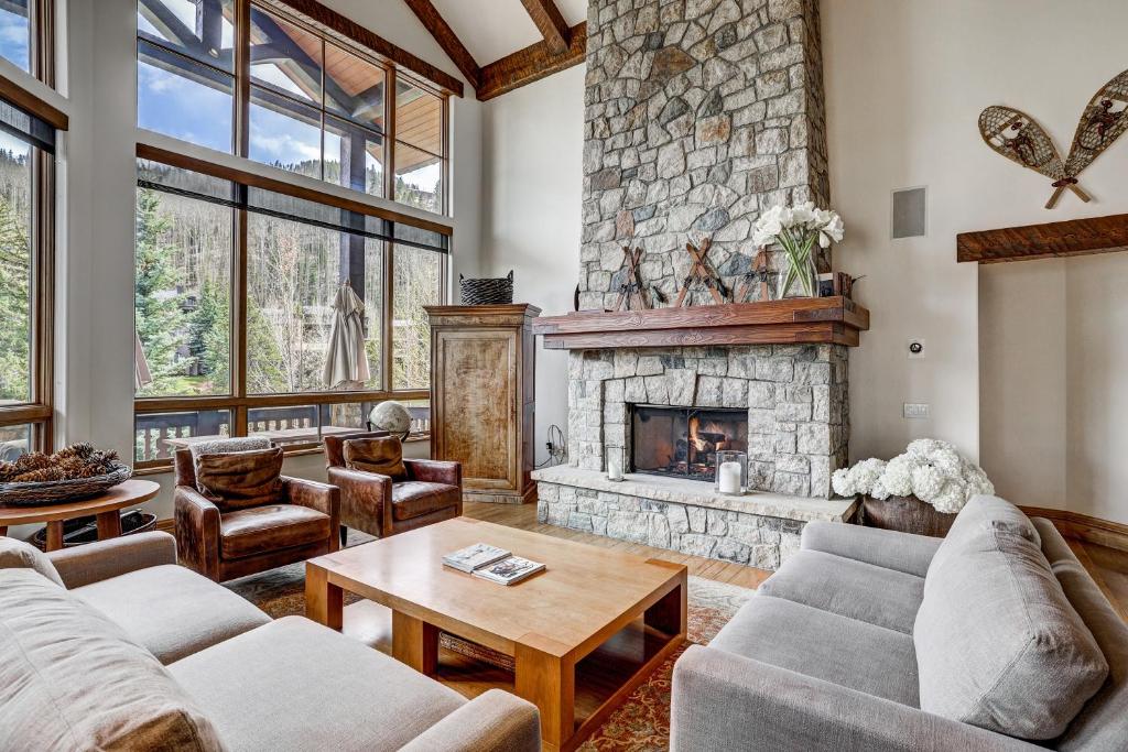 sala de estar con chimenea de piedra y sofás en Refined 5 BR Private Home with Private Hot Tub, en Vail