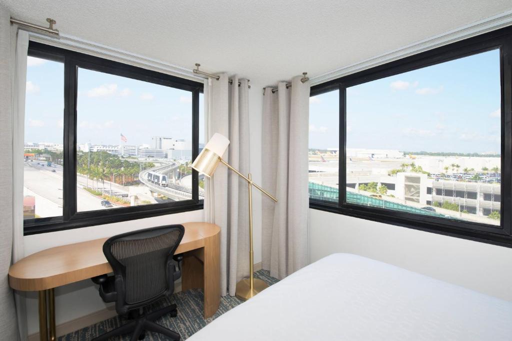 a hotel room with a desk and windows at Sheraton Miami Airport Hotel and Executive Meeting Center in Miami