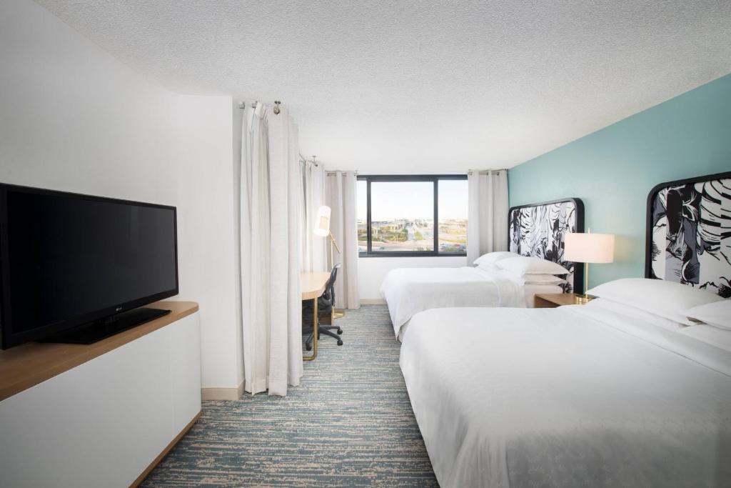 a hotel room with two beds and a flat screen tv at Sheraton Miami Airport Hotel and Executive Meeting Center in Miami