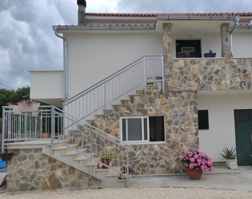 a stone house with stairs and a window at Apartman Lucia in Bilice