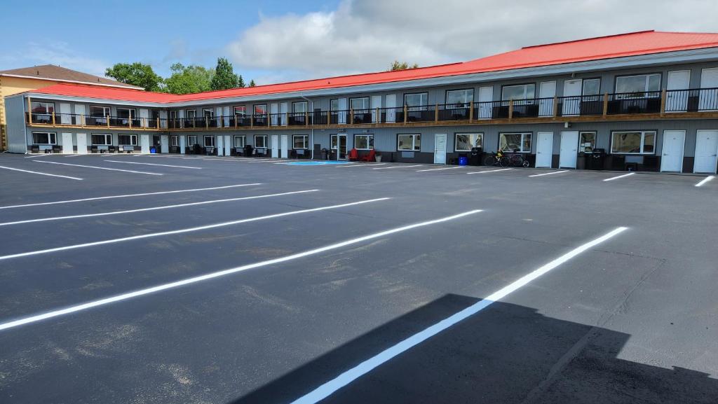 Un estacionamiento vacío frente a un edificio en Outdoorsman Motel, en Wawa