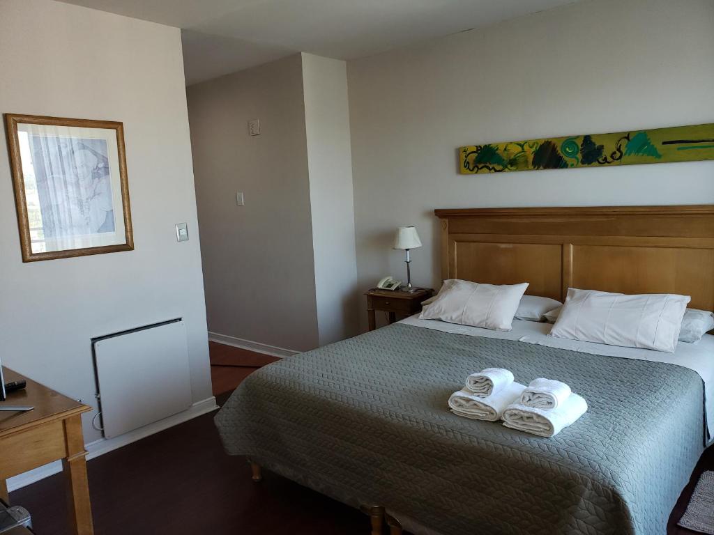 a bedroom with a bed with two towels on it at PREMIUM MENDOZA in Mendoza