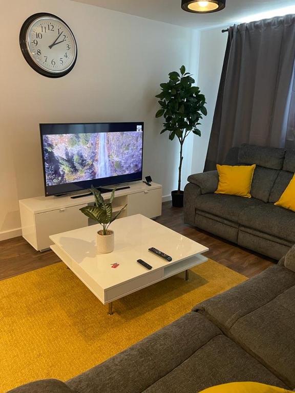 ein Wohnzimmer mit einem TV und einem weißen Couchtisch in der Unterkunft Defining Luxury, Comfort& Class2 in Barking