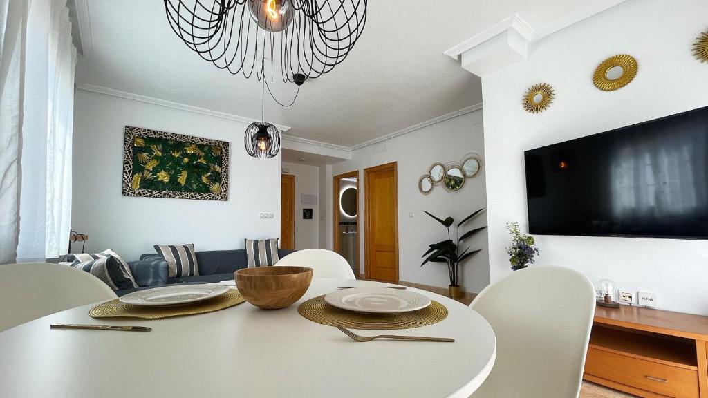 a white dining room with a white table and chairs at Modern 2 Bedroom Apt 200m to Beach Full Air Con in San Pedro del Pinatar