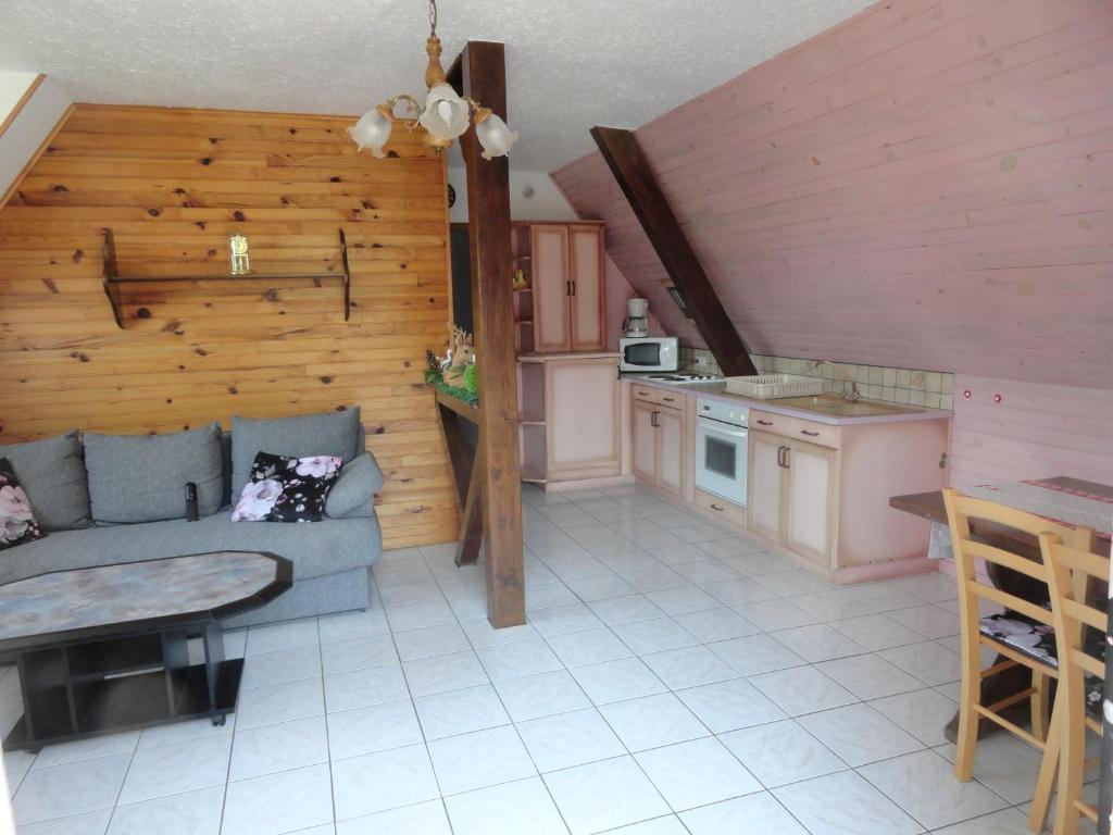 a living room with a couch and a kitchen at GÏTE LA DANSE DES BICHES in Ranspach
