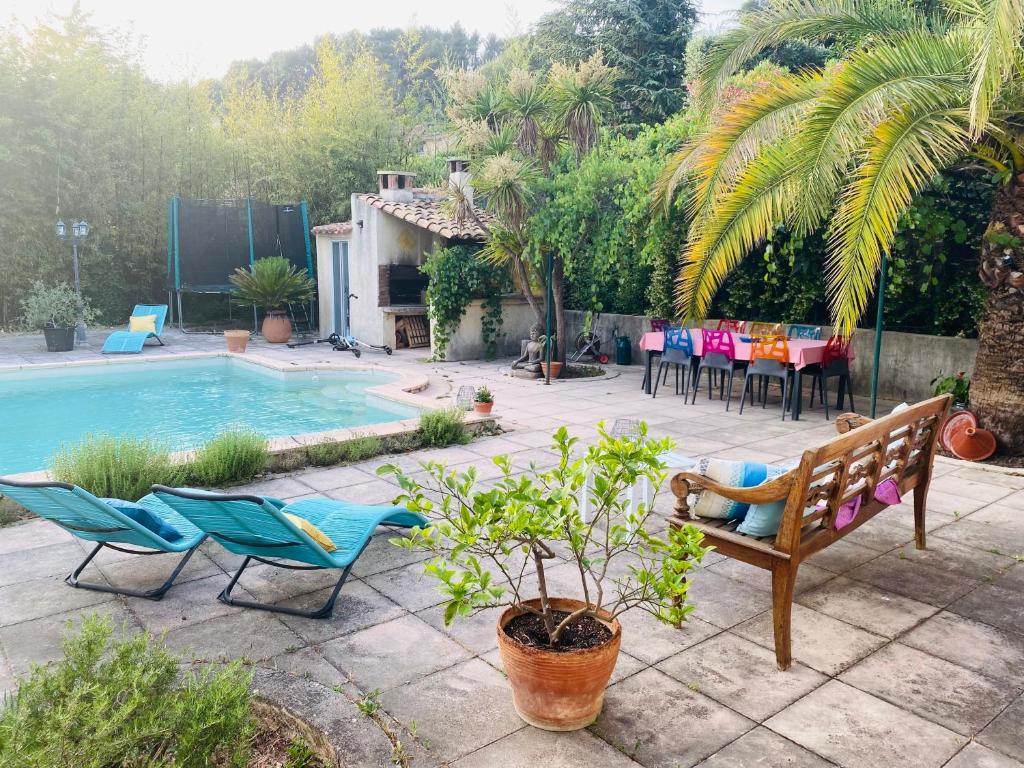 a patio with two chairs and a swimming pool at Chambre d hôte Entre Cigale et Pagnol in Peypin