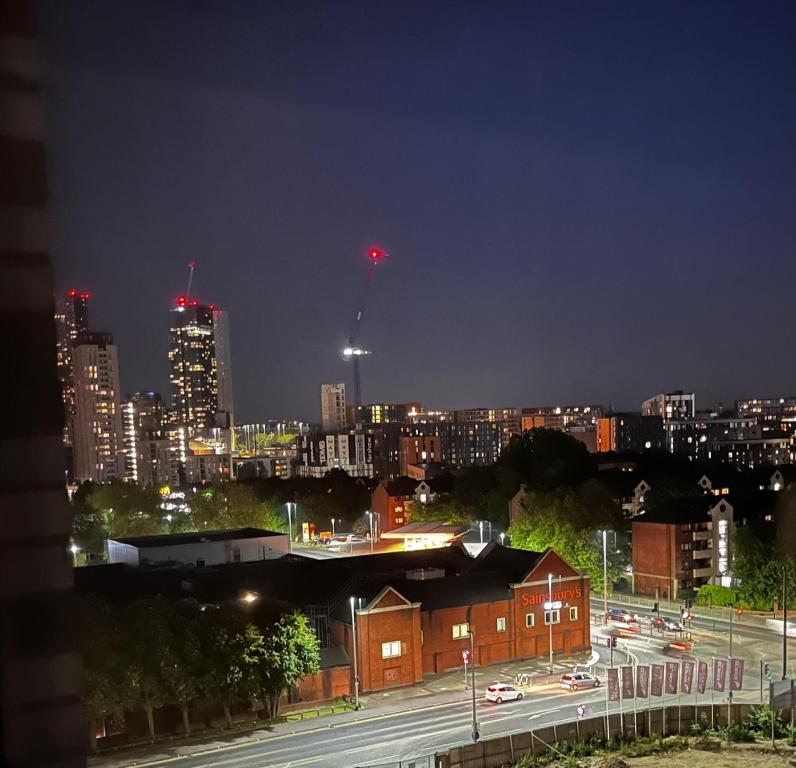 - une vue sur la ville la nuit avec une lumière rouge dans l'établissement Executive Luxury stays 3, à Barking