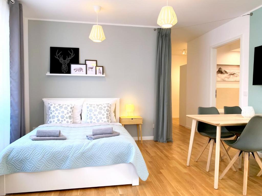 1 dormitorio con 1 cama, mesa y sillas en Moderne Ferienwohnung mit bodentiefer Dusche, Waschmaschine und Küche - "Hoffi", en Leipzig