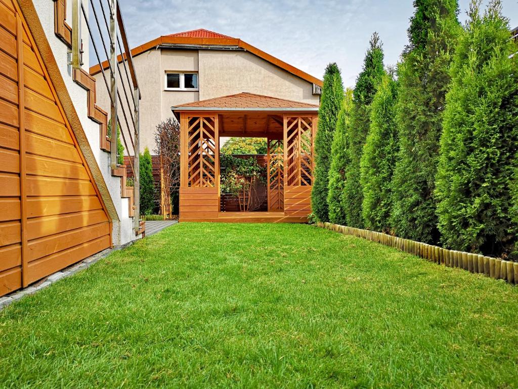 a wooden gazebo in the middle of a yard at Apartament Morski z ogródkiem in Rumia