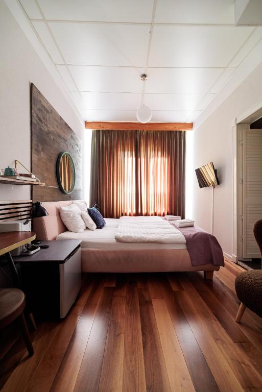 a bedroom with a large bed and a desk at Hotel Auberge Nassau in Eindhoven