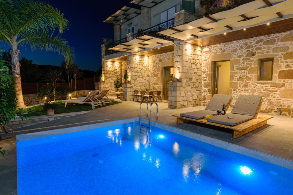 a villa with a swimming pool at night at Effrosini Traditional Home in Nopíyia