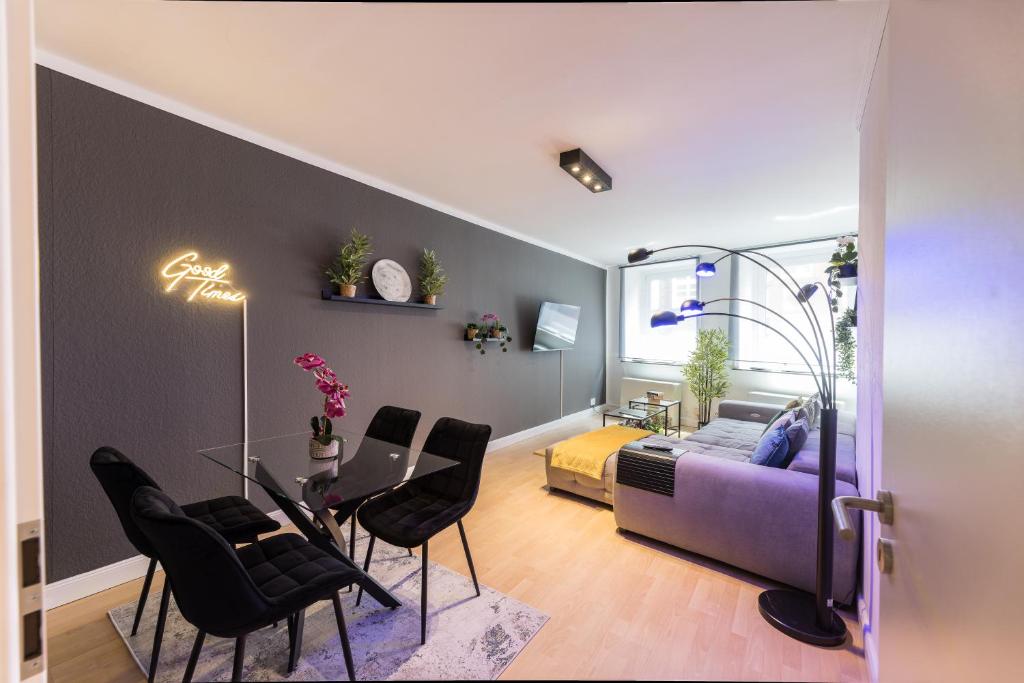 ein Wohnzimmer mit einem lila Sofa und schwarzen Stühlen in der Unterkunft The Harbour Apartment 2 in Hamburg
