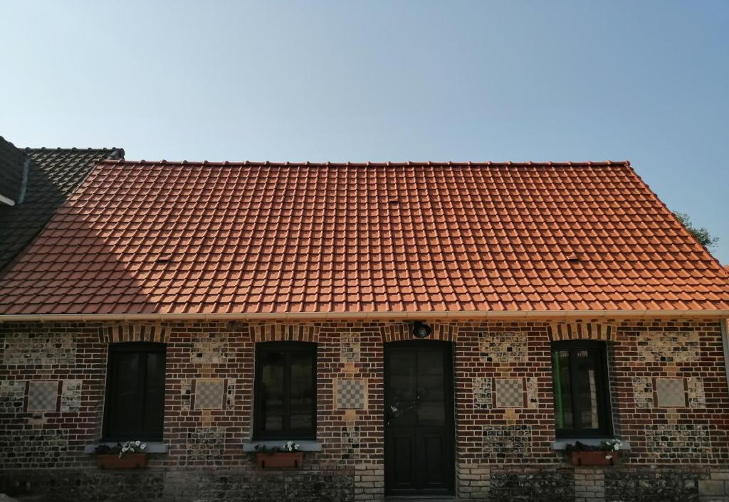 an orange tile roof on a brick building at Les Magnolias in Tourville-la-Chapelle