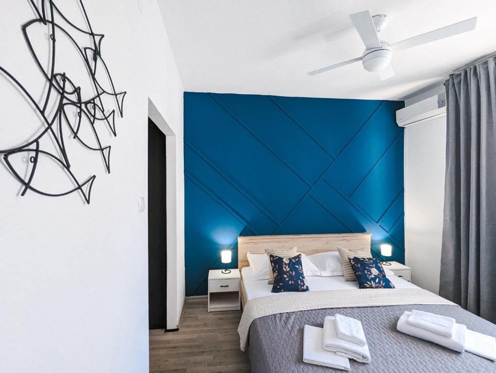 1 dormitorio con pared de acento azul en Wind Rose Rooms, en Baška Voda