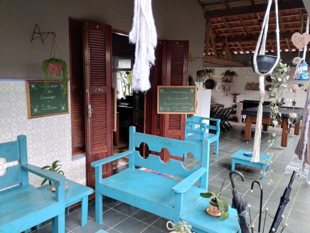 uma sala de aula com cadeiras azuis e um quadro negro em Hostel Familiar Artesanal em Ubatuba